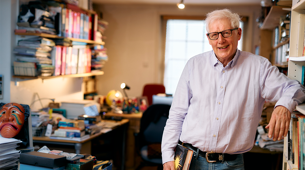 TV producer and author John Withington in his home office leaning against his bookshelf
